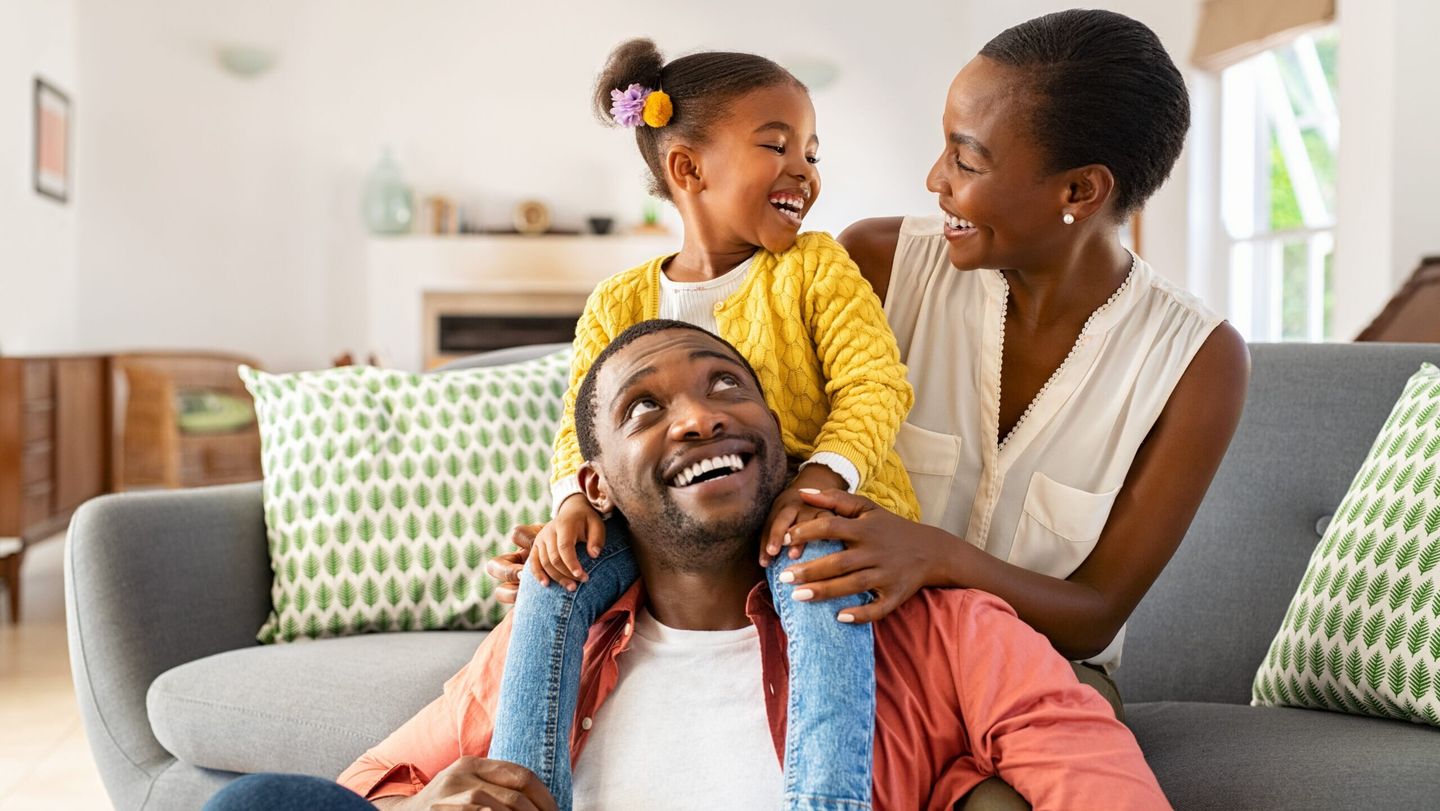 Little black girl playing with parents at home Top 5 cities for Black households, best cities for Black Americans, Juneteenth, theGrio.com